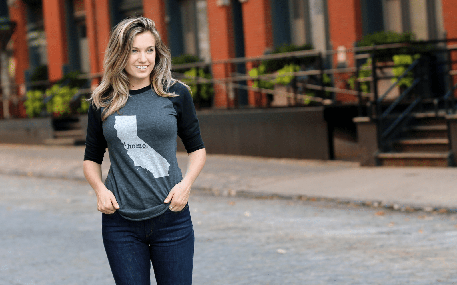 Woman wearing California home shirt walking on urban street